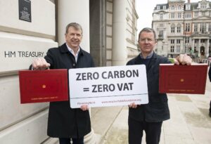 David Cowdrey and Richard Hauxwell-Baldwin, from the MCS Foundation, holding a 'ZERO CARBON = ZERO VAT' sign.