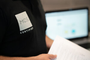 Person wearing black polo with MCS certified logo on.