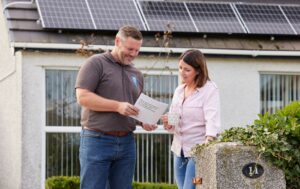 Sian and Chris stood outside of house with solar PV.